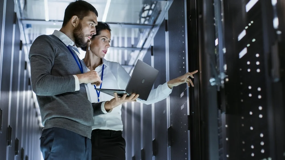 Twee IT-professionals analyseren samen een serverinstallatie